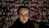 Hajra Catic, 70, who lost her husband and son in the 1995 Srebrenica massacre, poses for a portrait, backdropped by photos of the dead and missing, in Tuzla, Bosnia. Nov. 11, 2017.