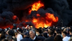 Njerëzit mblidhen pranë një zjarri gjatë një proteste anti-qeveritare të studentëve në Tiranë, Shqipëri, më 14 tetor 2026.