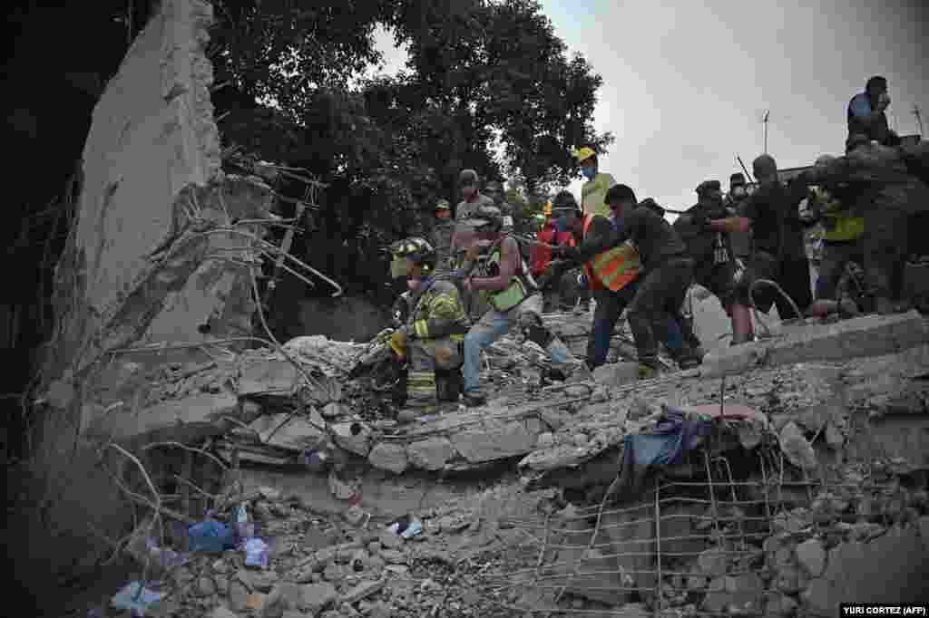 MEXICO -- Rescuers, firefighters, policemen, soldiers and volunteers remove rubble and debris from a flattened building in search of survivors after a powerful quake in Mexico City on September 19, 2017.