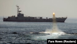 An Iranian warship and speed boats take part in a naval war game in the Persian Gulf and the Strait of Hormuz in 2010.