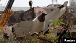 Кран ги отстранува остатоците од Боинг 787-8 Дримлајнер на Ер Индија кој се урна при полетување од аеродромот во Ахмедабад, Индија, на 14 јуни 2025 година.