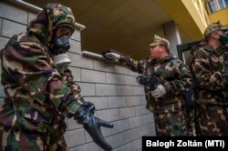 Budapesti iskola fertőtlenítéséhez öltöznek be a 93. Petőfi Sándor Vegyivédelmi Zászlóalj katonái 2021. március 17-én