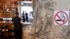 Montenegro -- A "no smoking" sign stands on a wall as a man waits at a bar counter in Podgorica, August 14, 2019