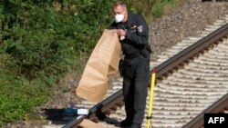 Полицейские убирает очередную обнаруженную бомбу с железнодорожных путей