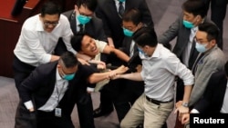 Күзетшілер демократтардың бірін парламент залынан күштеп шығарып жатыр. Гонконг, 18 мамыр 2020 жыл.