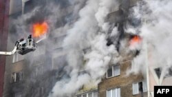 Salvatorii ucraineni sting un incendiu izbucnit într-un bloc de locuințe după un atac cu rachete asupra Kievului, 7 februarie 2024.