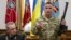 A Ukrainian military commander (right) shows a rifle seized from Russian soldiers as Colonel General Viktor Muzhenko, chief of the General Staff and commander-in-chief of the armed forces of Ukraine, looks on during a news conference in Kyiv on May 18.
