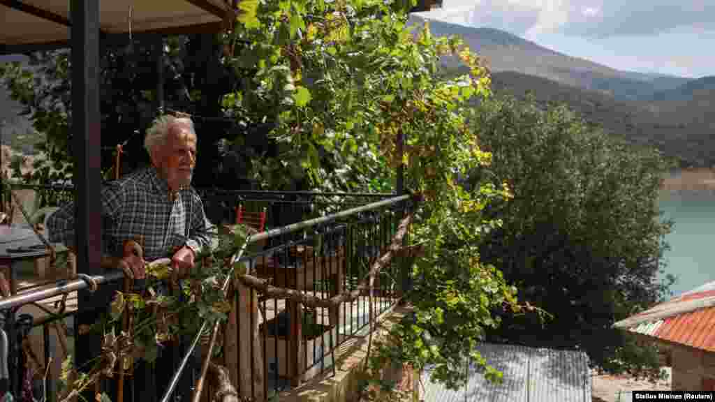 Konstantinos Gerodimos, 90, bivši stanovnik prvog sela Kalio, koje je namjerno potopljeno 1980. godine da bi se stvorilo jezero Mornos, rezervoar koji bi pomogao da se podmire potrebe vode grčke prestonice, Atine, u svom domu, u novom selu Kalios, Grčka, 3. septembar 2024.