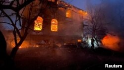 მეხანძრე მუშაობს საცხოვრებელი შენობის ტერიტორიაზე, რომელიც დაზიანდა რუსეთის სარაკეტო და დრონებით განხორციელებული იერიშების შედეგად. კიევი, 27 დეკემბერი, 2025 წელი