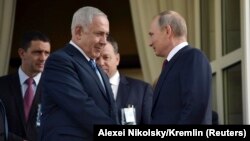 Presidenti rus, Vladimir Putin (djathtas) derisa takon kryeministrin izraelit, Benjamin Netanyahu në një takim në Soçi në gusht të vitit të kaluar.