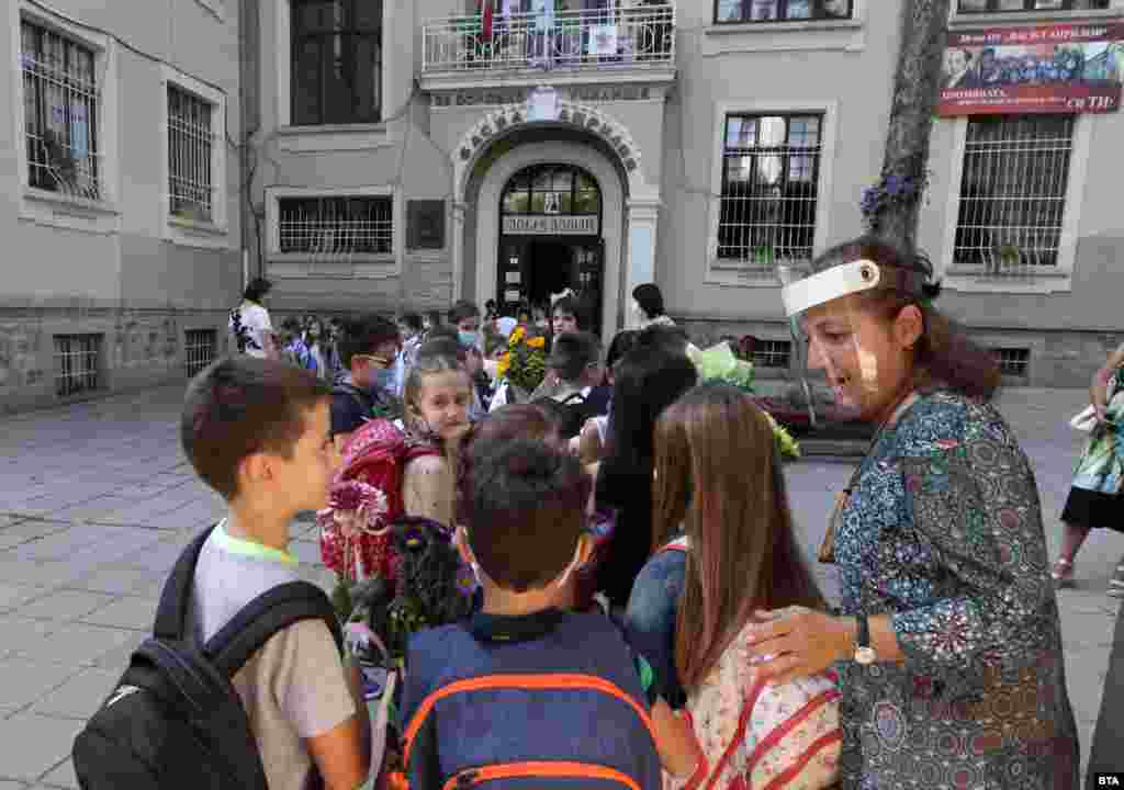 Учителка с предпазен шлем посреща учениците си в столичното 38-о училище &quot;Васил Априлов&quot;.