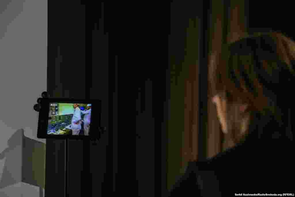 Відвідувачка виставки дивиться трансляцію закриття ЧАЕС. Станцію закрили під тиском міжнародної спільноти для гарантування безпеки.Це відбулося 5 грудня 2000 року за наказом президента Леоніда Кучми – саме з тих пір ЧАЕС більше не виробляє електроенергію