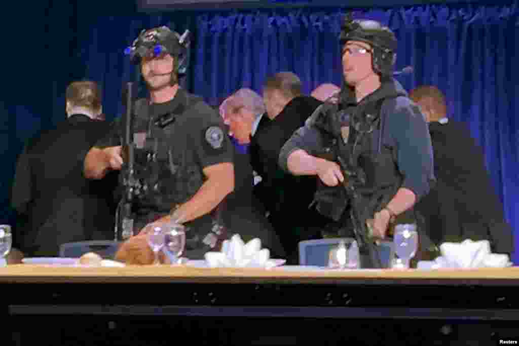 Agenti Tajne službe izvode američkog predsjednika Donalda Trumpa i njegovu suprugu Melaniju Trump nakon što su odjeknuli pucnji na večeri Udruženja dopisnika Bijele kuće, organizovanoj u hotelu Washington Hilton, 25. aprila.