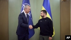 Secretarul general al NATO, Jens Stoltenberg, stânga, este întâmpinat de președintele ucrainean Volodimir Zelenski, Kiev, Ucraina, 20 aprilie 2023