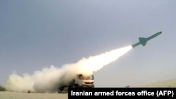 A missile is fired out to sea from a mobile launch vehicle reportedly on the southern coast of Iran along the Gulf of Oman during a military exercise, June 17, 2020