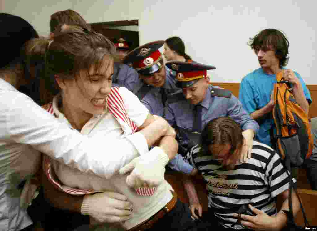 Police remove Nadezhda Tolokonnikova (left), Oleg Vorotnikov (bottom right), and other activists of the art group Voina from the court after they disrupted a hearing against the director of the Sakharov Center in Moscow in May 2009.