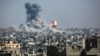A ball of fire and a column of smoke erupts following Israeli bombardment of areas east of a neighborhood in eastern Gaza City on June 18. 