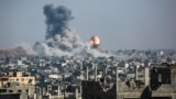 A ball of fire and a column of smoke erupts following Israeli bombardment of areas east of a neighborhood in eastern Gaza City on June 18. 