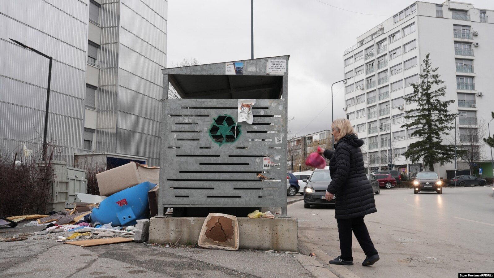 Një grua duke hedhur një qese me mbeturina në një kontejner në Prishtinë. Pastrimi kërkoi nga qytetarët mirëkuptim deri në largimin e mbeturinave interte dhe vëllimore.