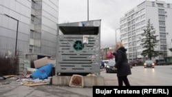 Një grua duke hedhur një qese me mbeturina në një kontejner në Prishtinë. Pastrimi kërkoi nga qytetarët mirëkuptim deri në largimin e mbeturinave interte dhe vëllimore.