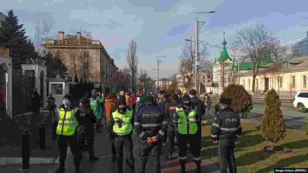 Sunt și antiprotestari la pichet. 10 persoane cu drapelul Republicii Sovietice Socialiste Moldovenești și pancarte pe care scrie Mișcarea de Eliberare Națională.