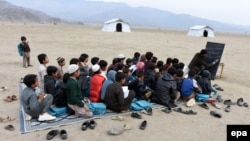 Afghan refugees who have returned from neighboring Pakistan attend an open-air school in Laghman Province in February.