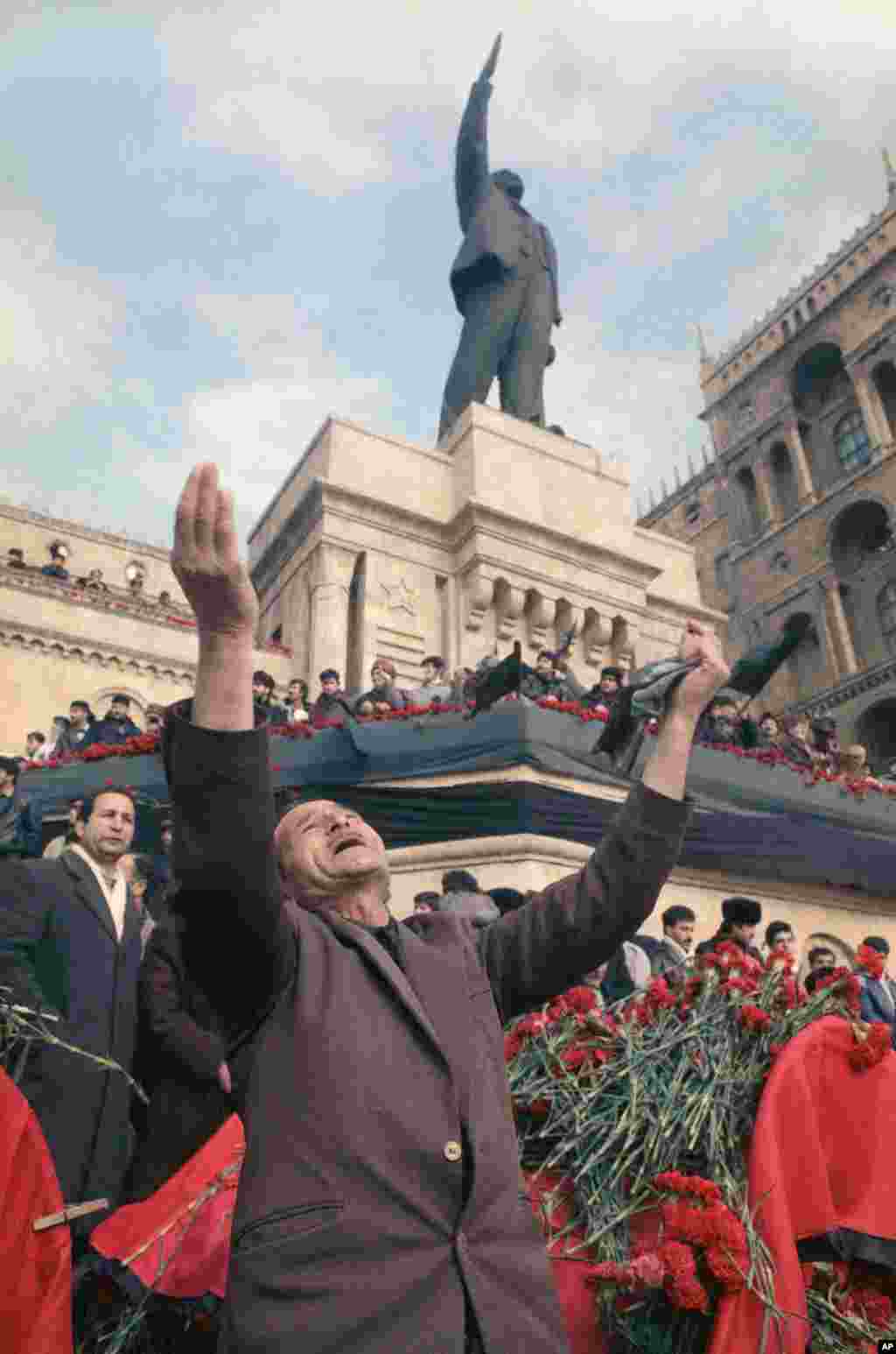 A man lifts his arms in grief under a statue of Lenin during a mass funeral in Baku.&nbsp;The traditional 40-day mourning period for the dead was marked by a national strike across Azerbaijan.