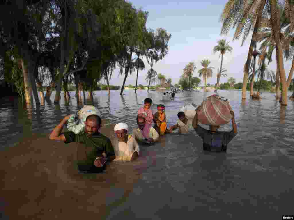 A family wades through floodwaters while evacuating Baseera, a village in Pakistan's Punjab Province, on August 10. The floods, triggered by unusually heavy monsoon rains over the upper Indus River basin that started nearly two weeks ago, have plowed a swathe of destruction more than 1,000 kilometers long from northern Pakistan to the south.Photo by Adrees Latif for Reuters