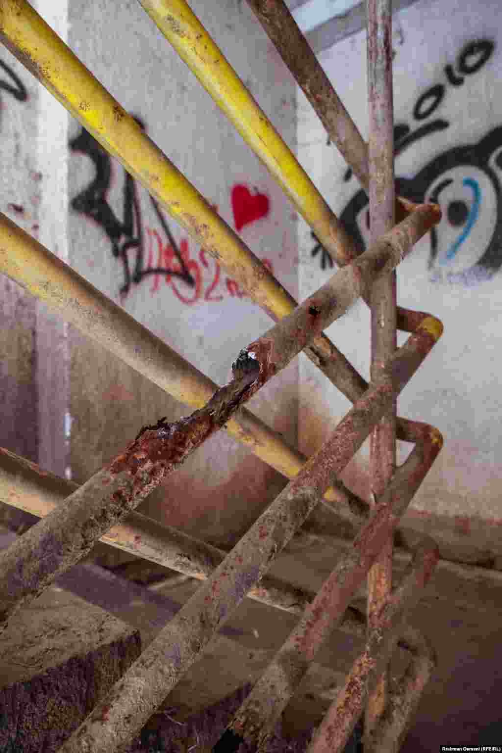 Grafite në mure dhe mbajtëse të ndryshkura të shkallëve. 