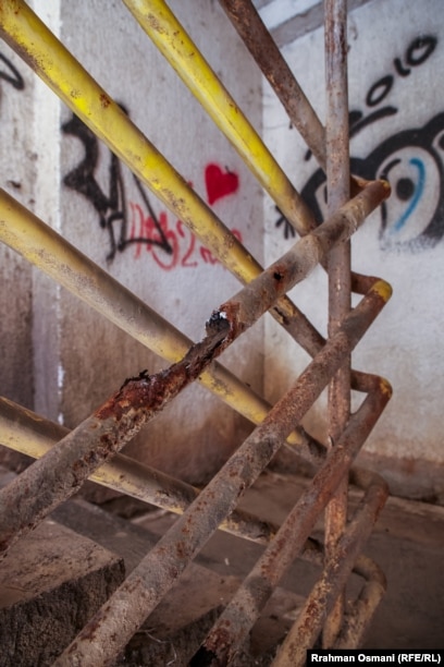 Grafite në mure dhe mbajtëse të ndryshkura të shkallëve. 