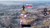 A Russian soldier hoists the Russian flag over Malaya Loknya in the Kursk region.