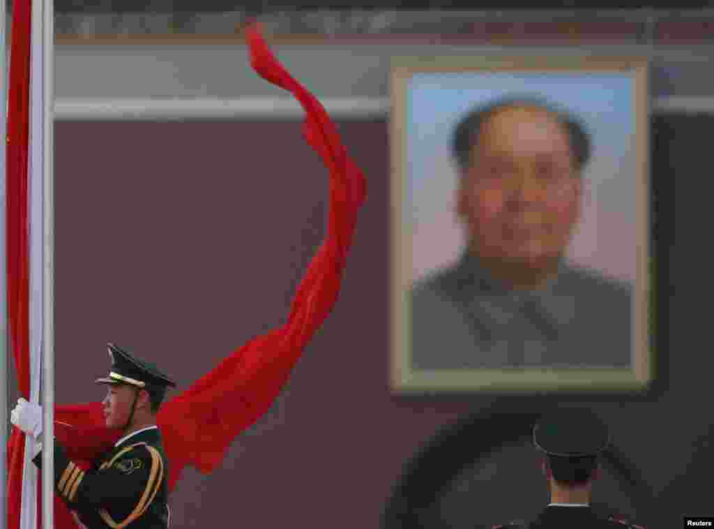 Drapelul chinez este cobor&acirc;t şi adunat de un ofiţer de poliţie &icirc;n piaţa Tiananmen din Beijing.