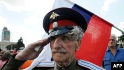 A veteran Cossack salutes in front of the Russian flag as pro-Russian militants take a military oath of allegiance to the so-called "Donetsk People's Republic" on June 22. 