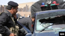 Security officers inspect a police vehicle after four police officers were killed in Quetta.