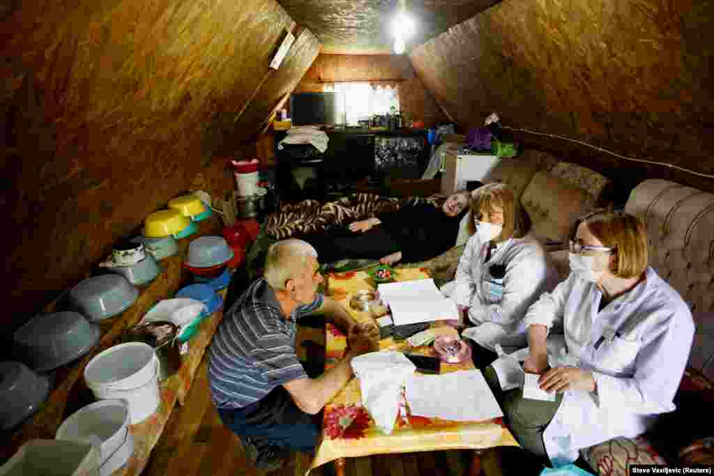 Workers prepare vaccine shots for an elderly couple.&nbsp; Montenegro received some 42,000 doses of the Pfizer/BioNTech vaccine from the European Union in early May.&nbsp;