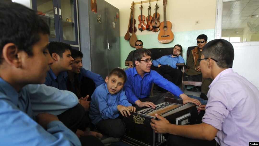 Visually impaired Afghan students play musical instruments during a music lesson at the Kabul Blind School.