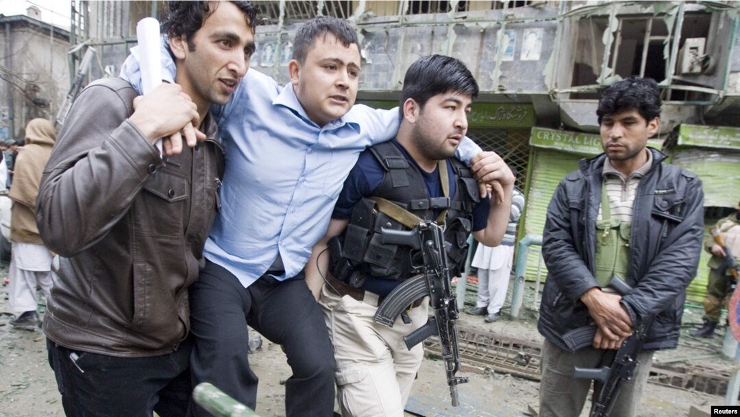 A wounded man is helped from the site of a blast near Kabul's biggest shopping center on February 26.