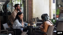 ABŞ bilen Eýranyň arasyndaky ok atyşygy bes etmek baradaky şertnamanyň arasynda, 21-nji aprelde Tährandaky bir kafede oturan eýranlylar.
