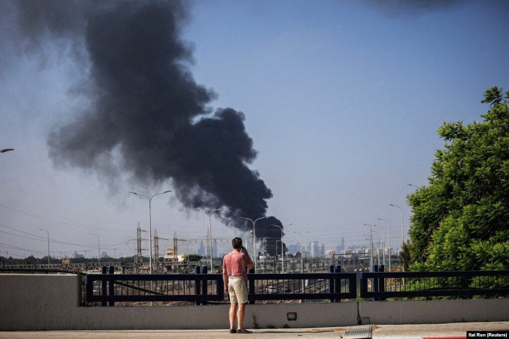 Një burrë izaelit duke shikuar tymin e zi që ngrihej pas një sulmi raketor nga Irani në Herzlija, më 17 qershor.