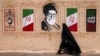 A woman walks past a mural depicting Iran's late supreme leader, Ali Khamenei, in central Tehran on August 8.