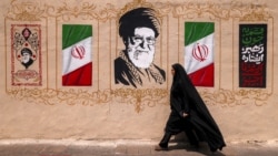 A woman walks past a mural depicting Iran's late supreme leader, Ali Khamenei, in central Tehran on August 8.