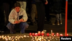 O tânără comemorează victimele incendiului de la Crans-Montana, Elveția, din noaptea de Revelion.