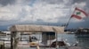 A fisherman stands in his boat at a port in Tyre