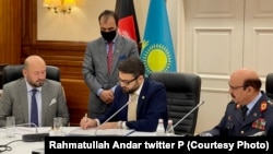 حمدالله محب، مشاور امنیت ملی افغانستان و نورلان یرمک بایوف، وزیر دفاع قزاقستان در هنگام امضای موافقتنامۀ همکاری نظامی بین دو کشور.