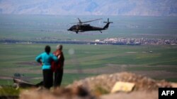 A medical helicopter from the U.S.-led coalition flies over the site of Turkish air strikes near the northeastern Syrian Kurdish town of Derik last month.