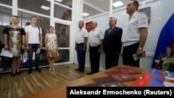 Russian Interior Ministry officials and residents of Ukraine's Donetsk region attend a passport ceremony in the village of Pokrovskoye in the Rostov region on June 14.