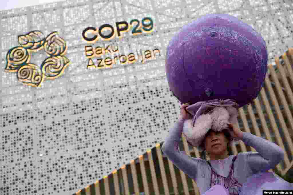 Chinese artist Kong Ning, wearing a specially made Purple Shells art installation, demonstrates at the entrance to the venue during the United Nations climate change conference COP29 in Baku on November 18.