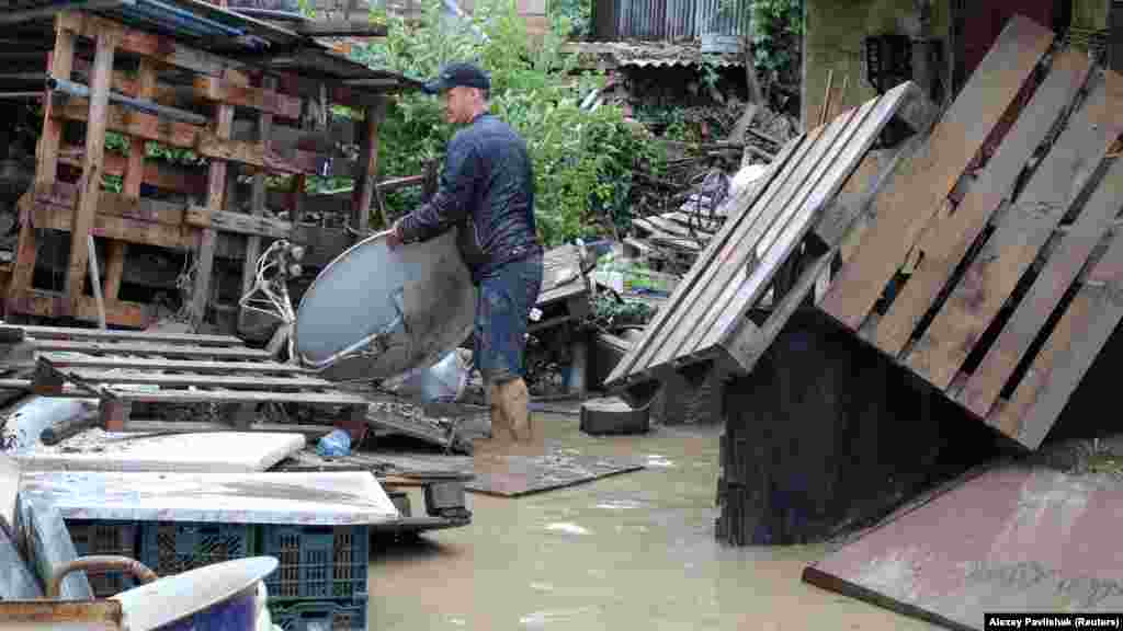 Местный житель оценивает ущерб после наводнения в Куйбышево