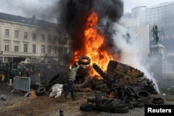 Protestatarii ard anvelope într-o piață din apropierea Parlamentului European, în semn de protest față de acordul de liber schimb UE-Mercosur, la Bruxelles, Belgia, 18 decembrie 2025.