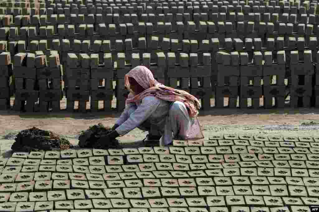 Laborer Mukhtara Bibi makes bricks at a factory on the outskirts of Lahore, Pakistan. (AFP/Arif Ali)